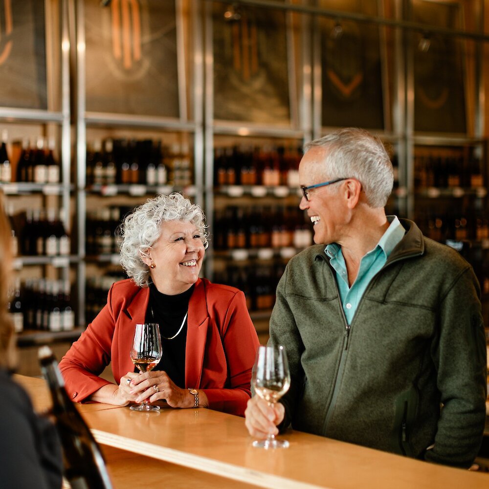 Couple smiling as they enjoy their wine tasting at Monte Creek Winery located near Kamloops, British Columbia.