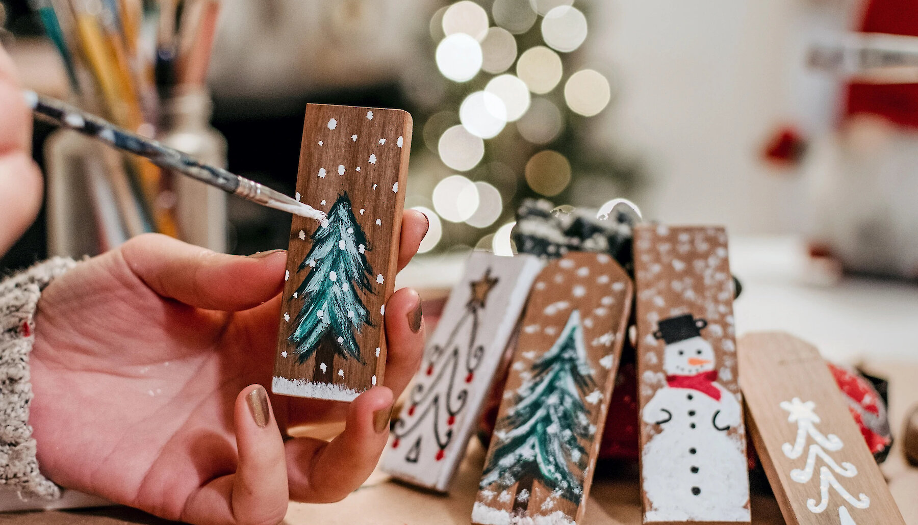 Crafter painting handmade Christmas Ornaments to be sold at a local craft fair.