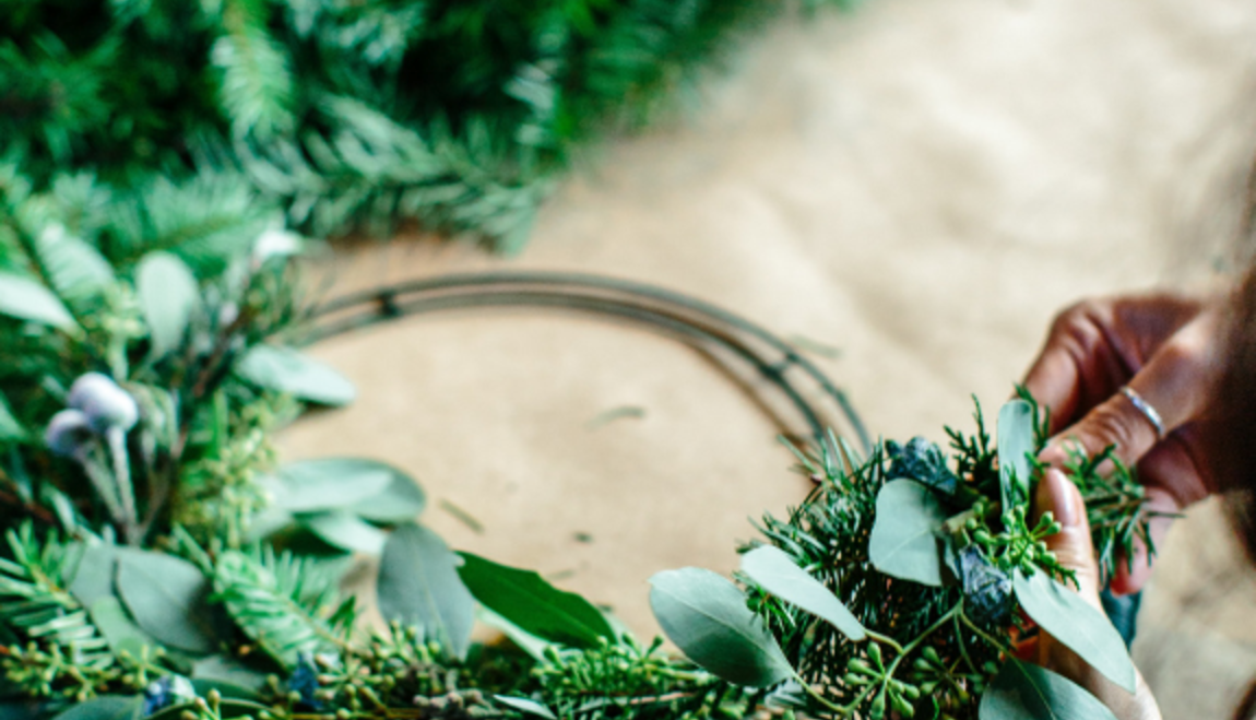 A woman crafting a handmade wreath in a wreath making workshop with Little Blue Barn Flowers in Kamloops, British Columbia