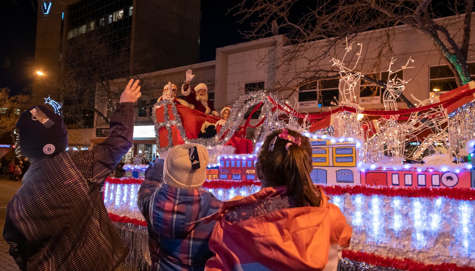 Children waving to Santa Claus on a Christmas float during the Santa Claus Parade located in downtown Kamloops, BC.