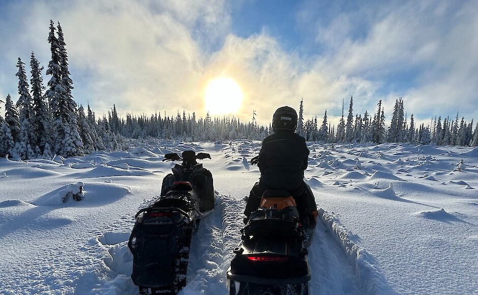 Group of snowmobilers riding through the powdery snow near Kamloops, BC.