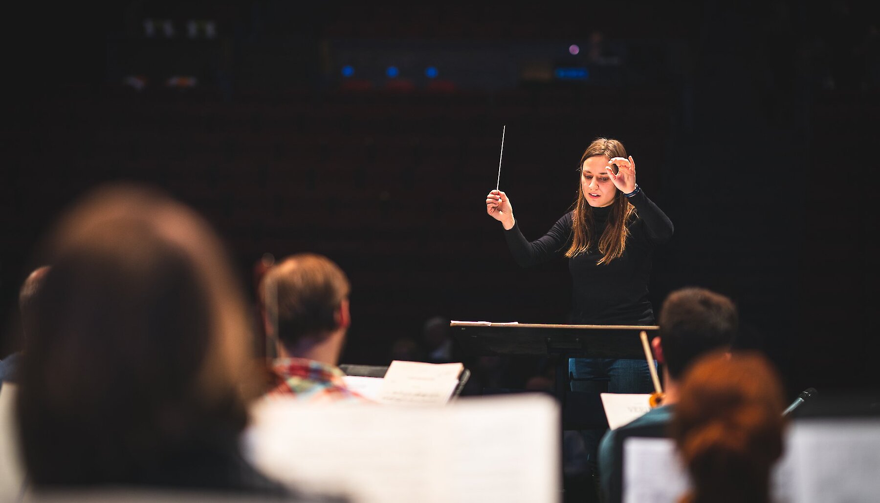 The conductor of the Kamloops Symphony is seen leading the orchestra through a performance