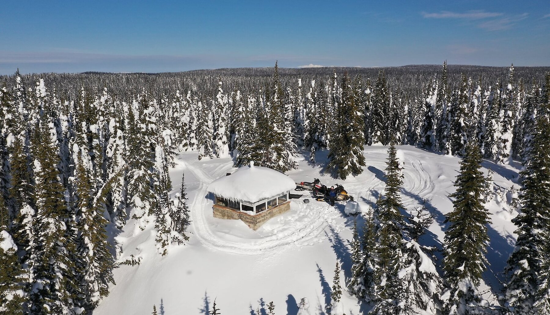 Snowy forest and warm-up shelter in Porcupine Ridge snowmobile riding area located near Kamloops, BC.