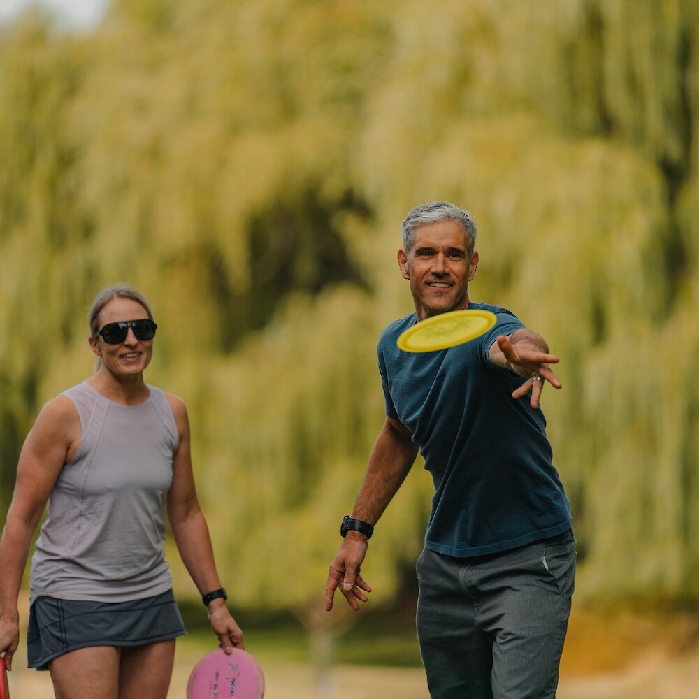 A couple on a date playing a Disc Golf game at the Disc Golf Park located on the North Shore.