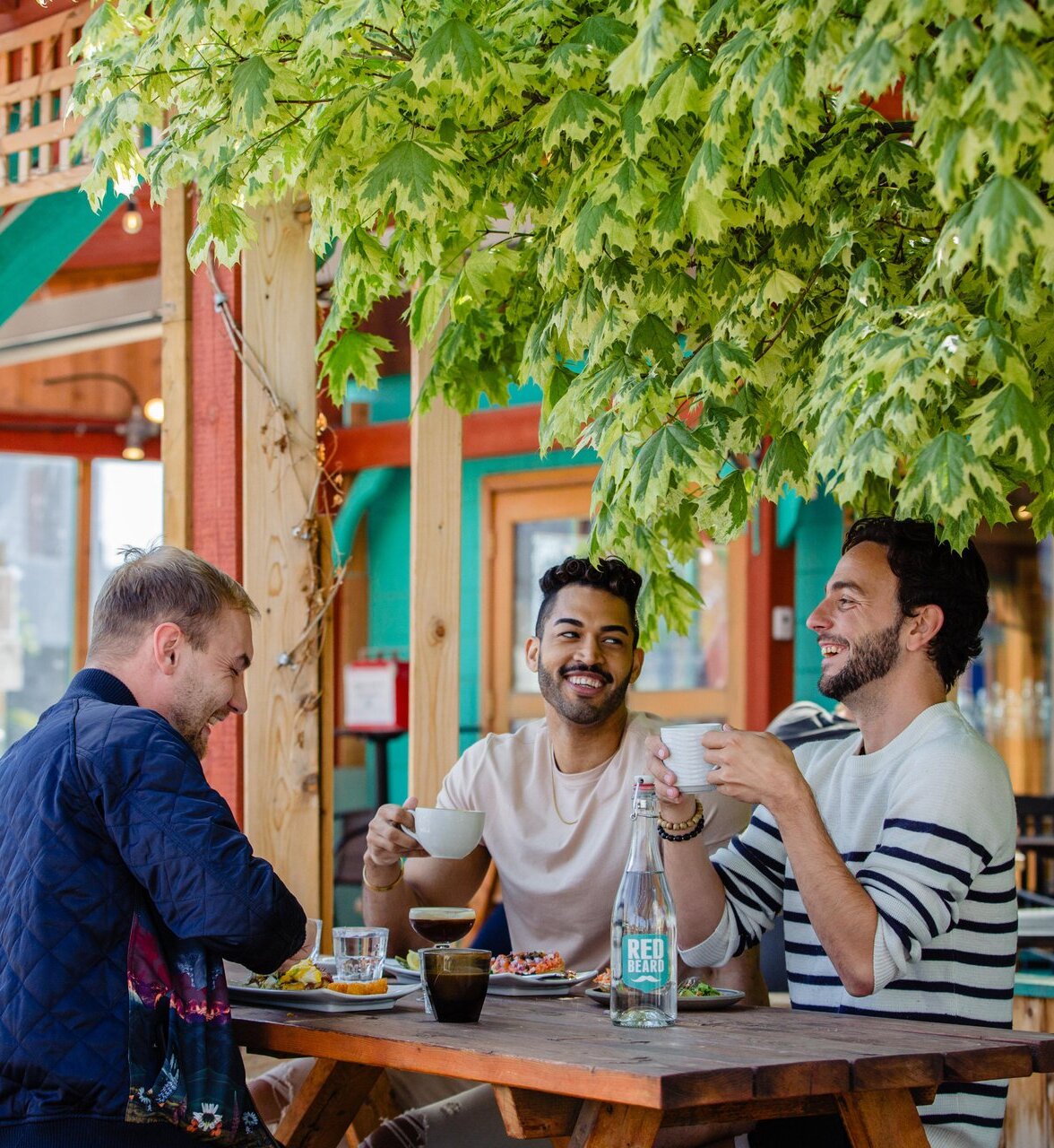 Three people eating at an outdoor patio restaurant table in Kamloops.