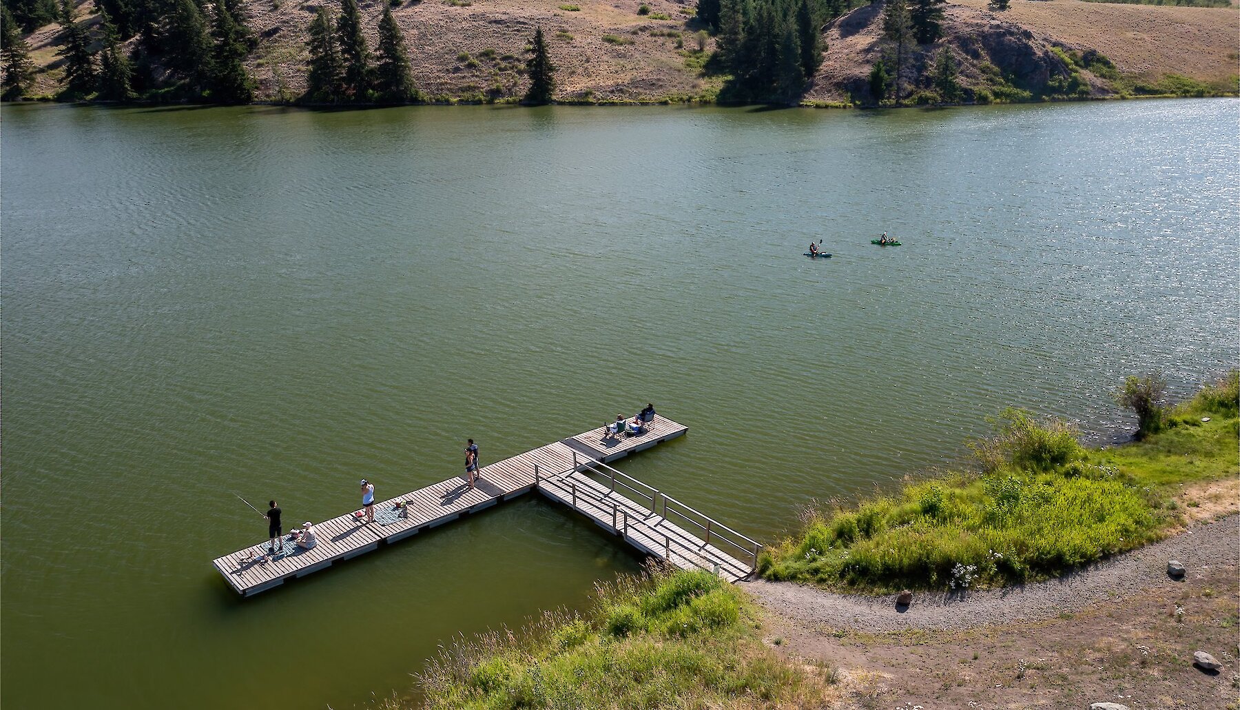 An aerial shot of people fishing off of a dock.