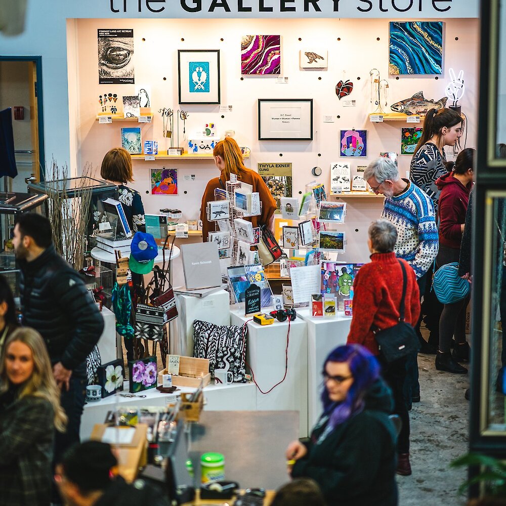 A crowd explores the merchandise at the gallery store.