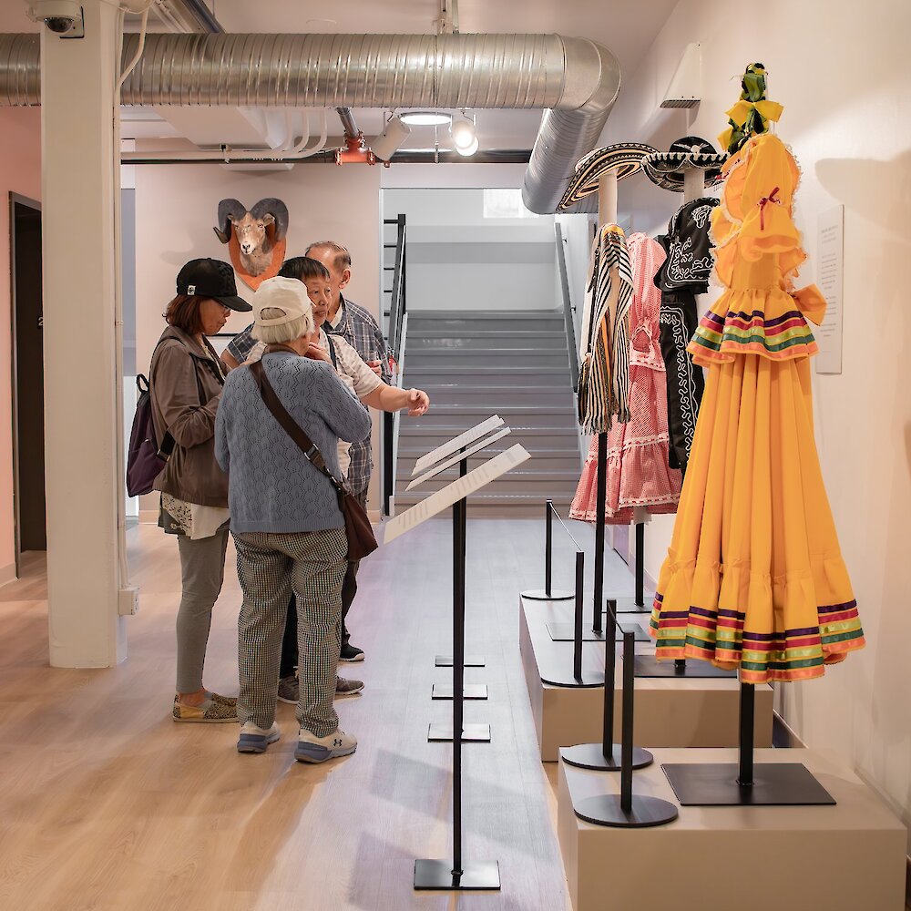 A group of people examine clothing artifacts.